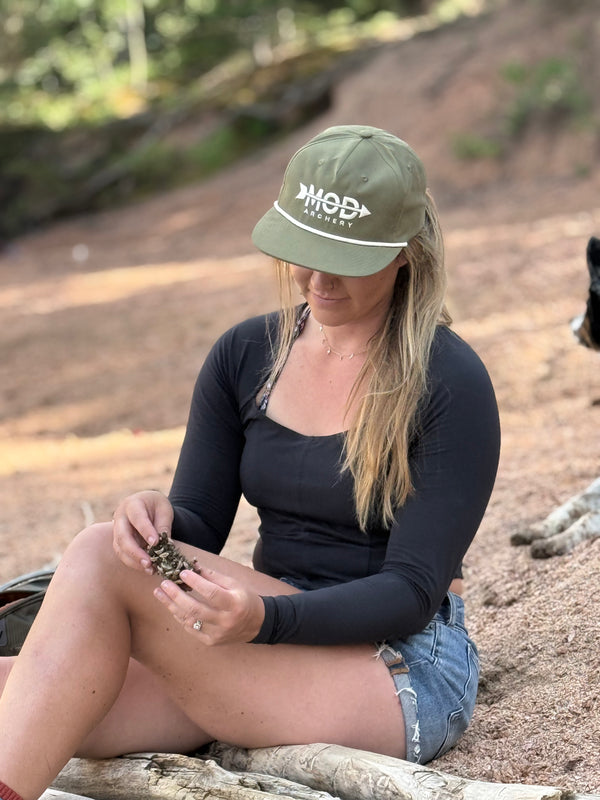 Woman wearing a green mod archery rope hat