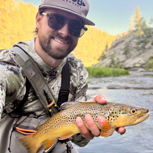 man holding a fish and wearing mod archery tan rope hat