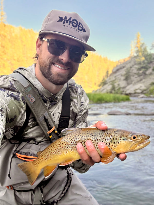 man holding a fish and wearing mod archery tan rope hat